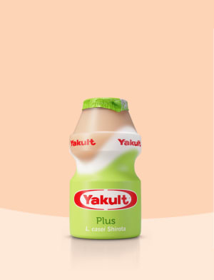 Yakult Plus Fläschchen auf beigem Hintergrund.