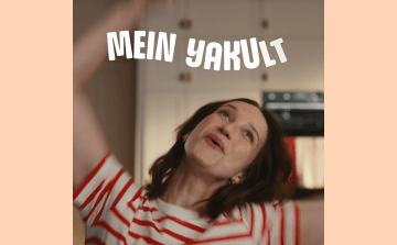 Tanzende Frau mit "Mein Yakult"-Schrift