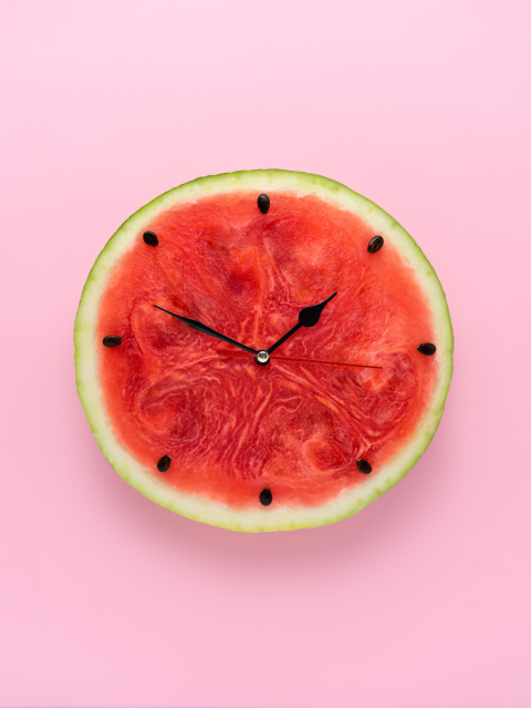 A watermelon clock on a pink background