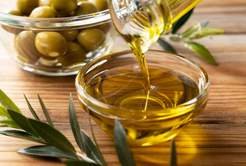 Bottle pouring Virgin Olive Oil In A Bowl, Close up