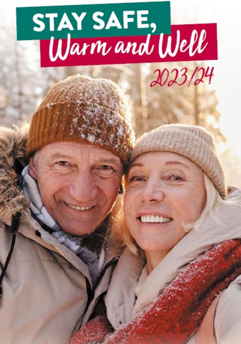 A smiling elderly couple wearing hats and scarves in the snow