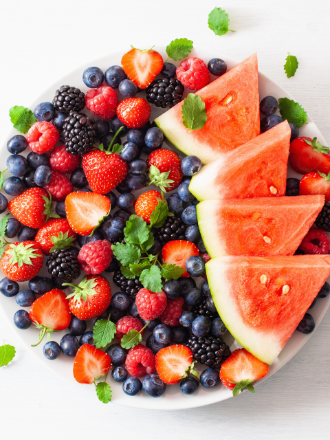 a plate of summer fruits including berries and watermelon