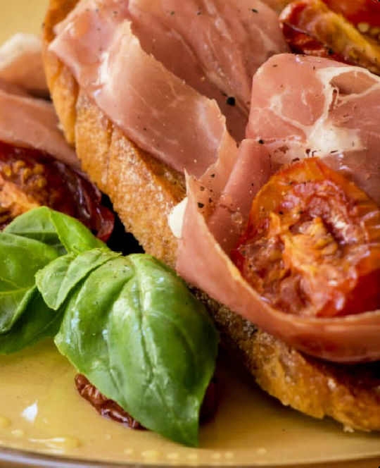 Ham on toast with tomatoes and fresh basil