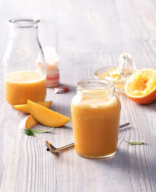 Smoothie met mango, sinaasappels met pers en flesje Yakult Original.