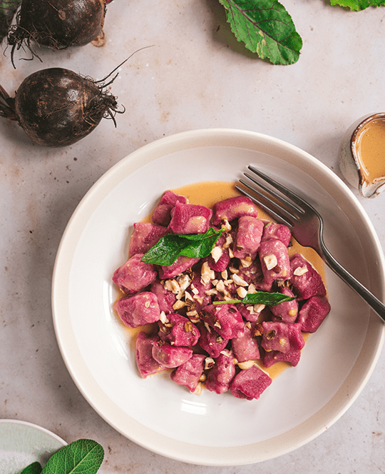 Rote-Rüben-Gnocchi auf einem Teller angerichtet.