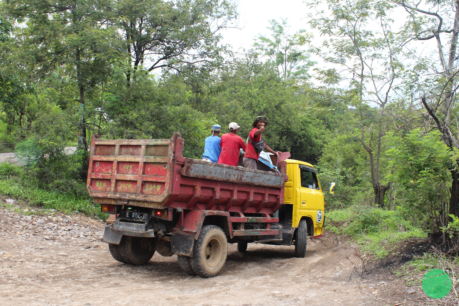 para pekerja di atas bak mobil truk yang sedang turun mengarah ke galian c kopi luhur