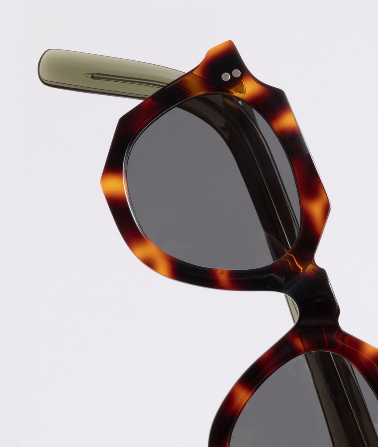 A macro shot of our FRONTs mod. Gargoyle by Bidules: a celluloid 50s demi-amber front matched with 70s acetate bottle green temples. It's a sunny with grey lenses.