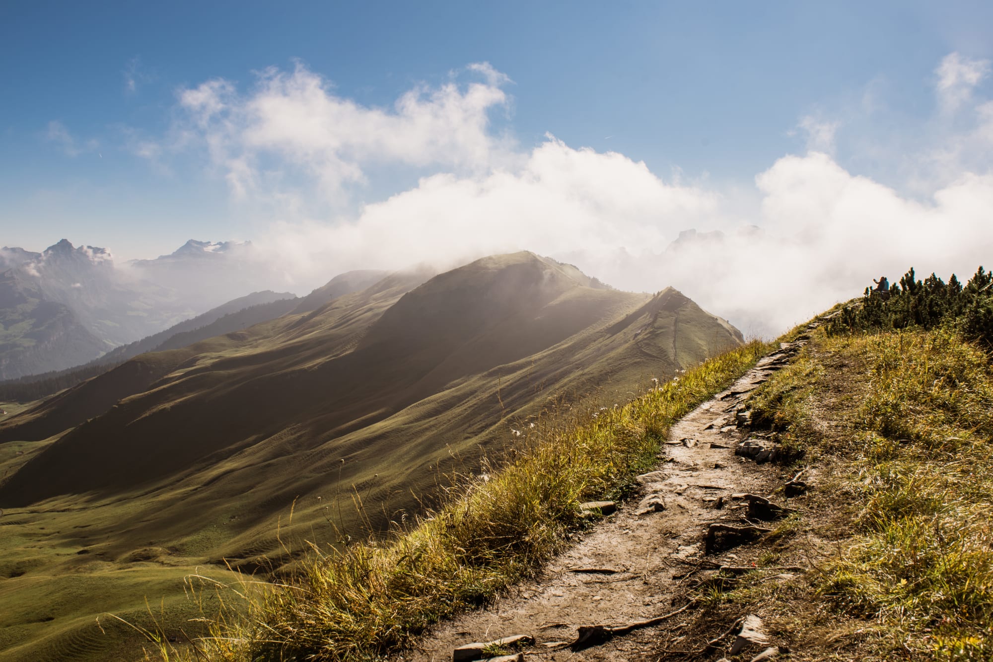Wanderweg mit Blick auf den Berg Stoos im Hintergrund, in herbstlicher Stimmung mit Nebel.