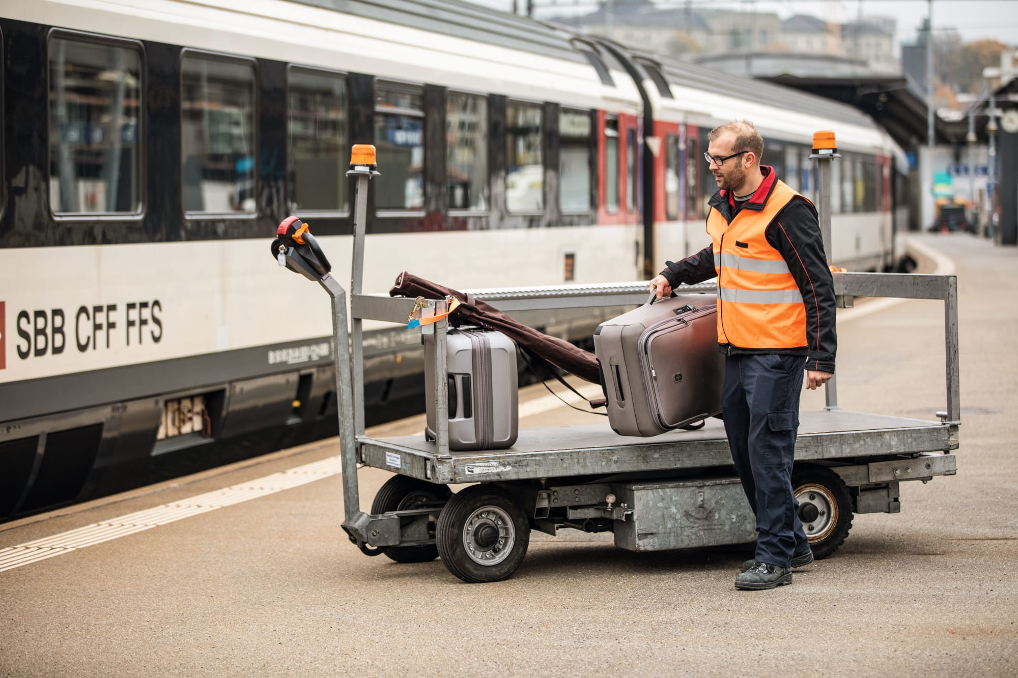 Un collaborateur des CFF charge des bagages dans un train