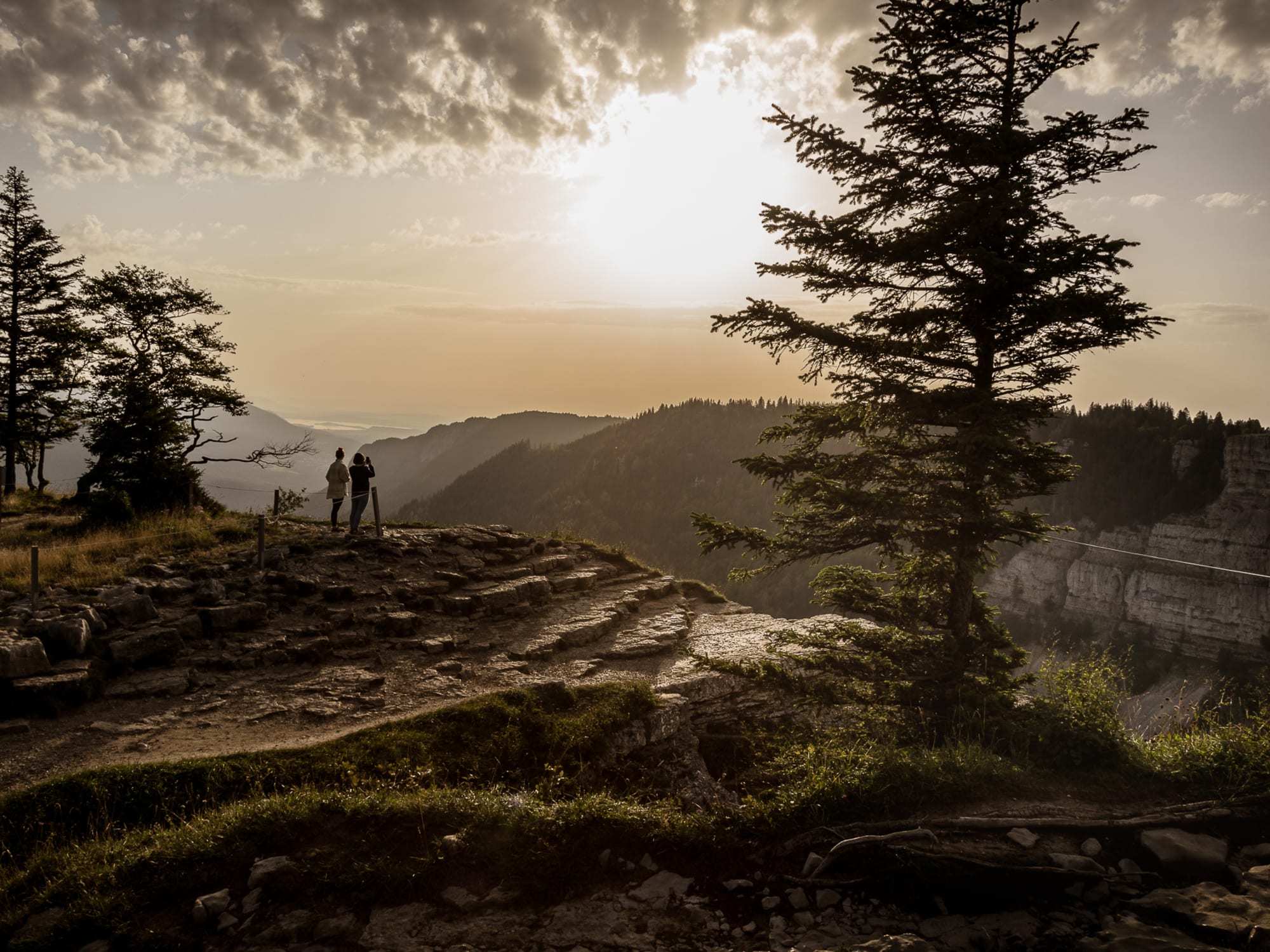 Deux personnes admirent la vue depuis le Creux-du-Van