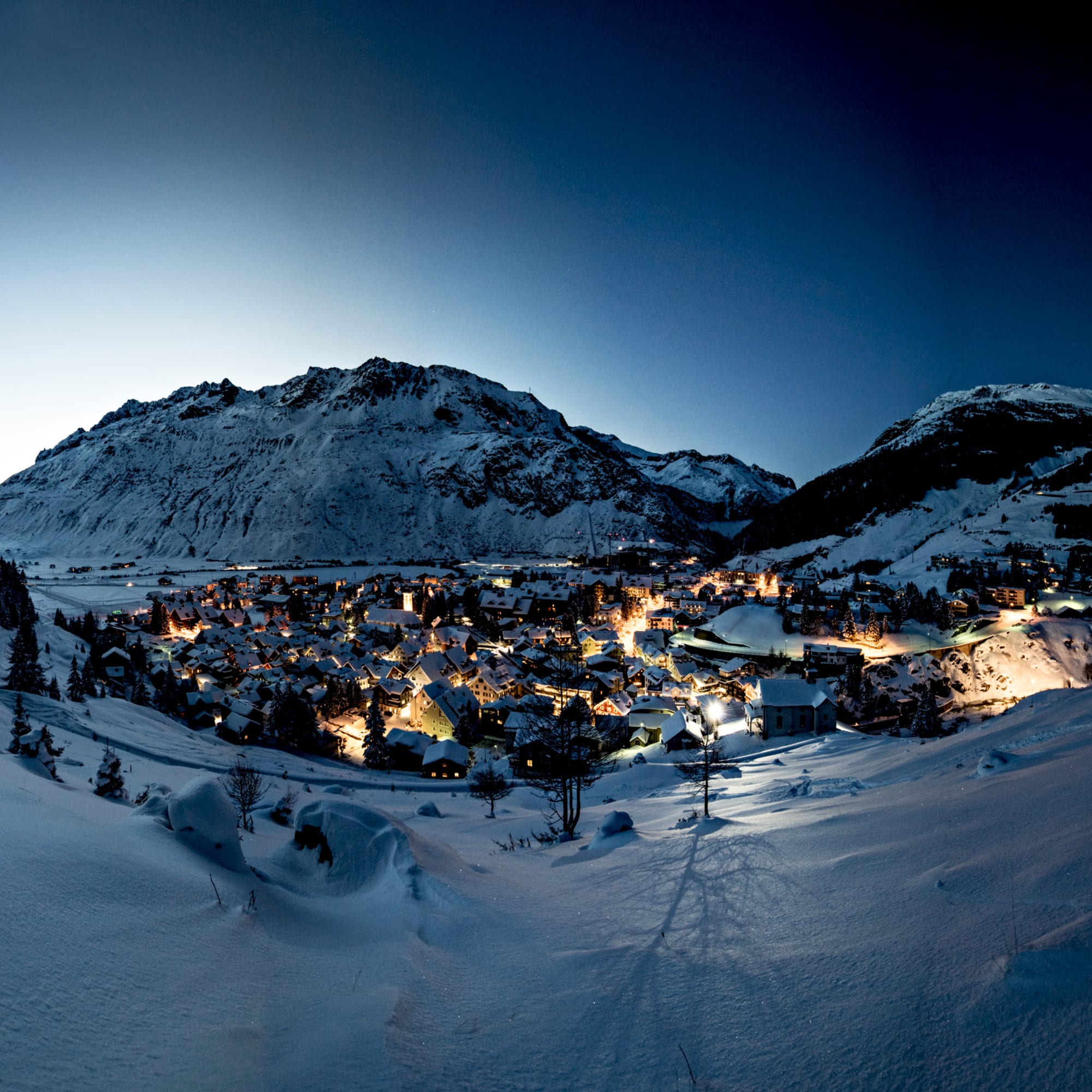 Village d'Andermatt recouvert de neige dans la nuit.