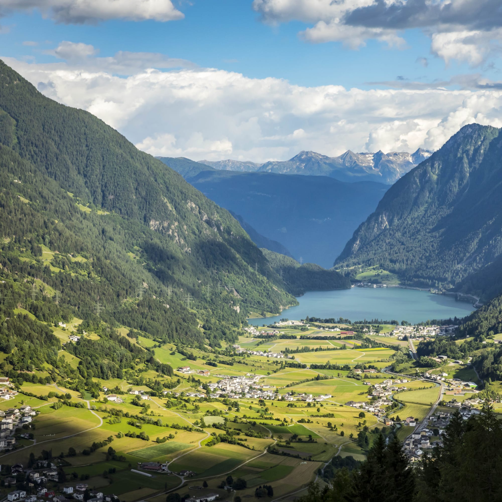 Panorama sur une vallée avec un petit lac bleu entre des montagnes