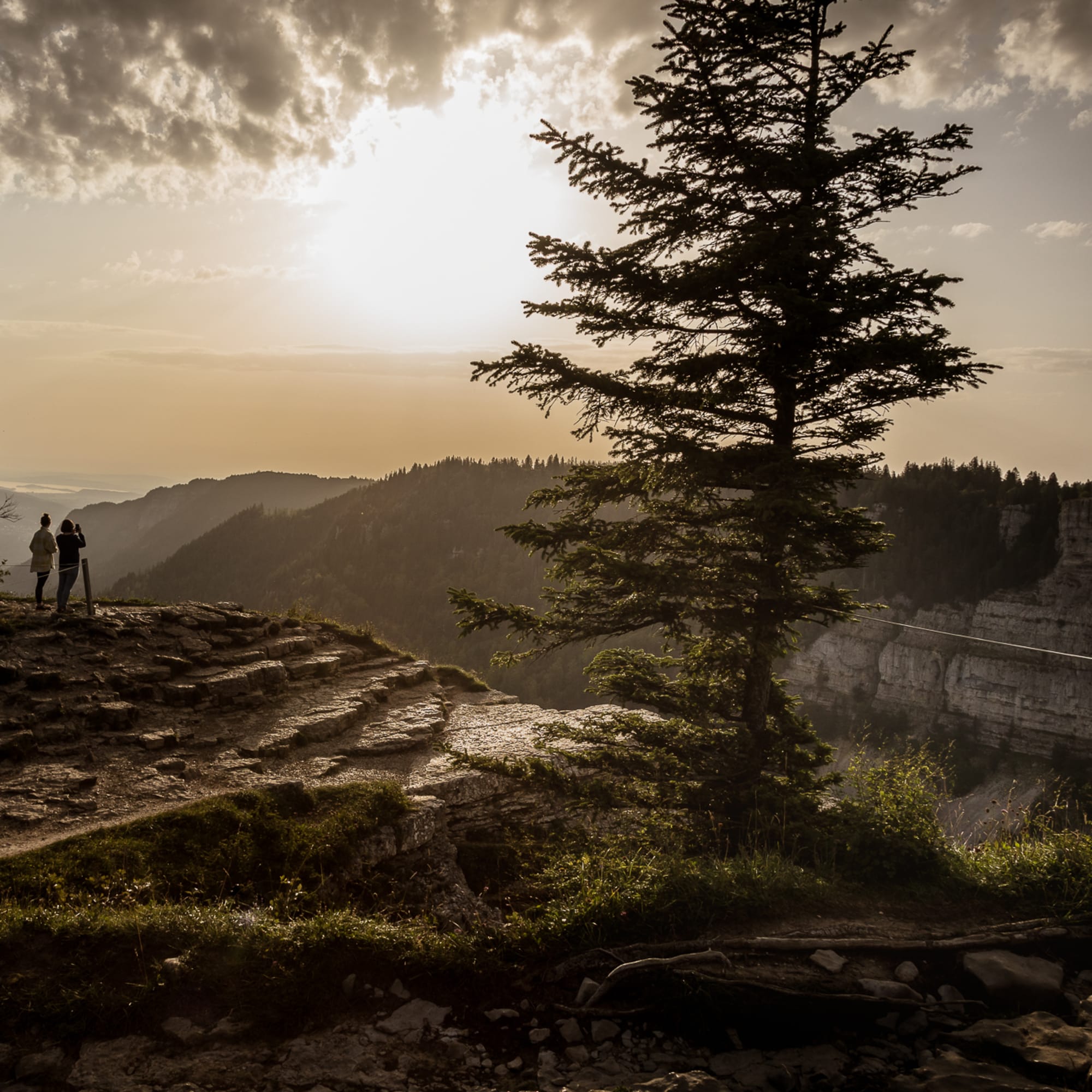 Deux personnes admirent la vue depuis le Creux-du-Van