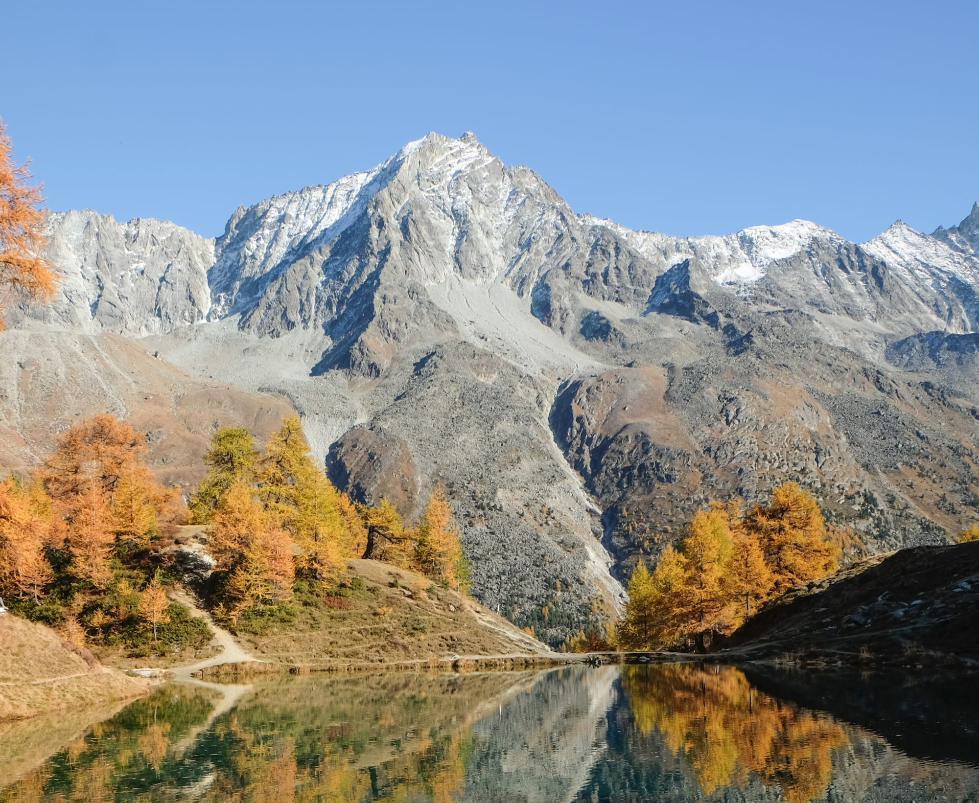 Le lac bleu d'Arolla dans la région d'Evolène devant des montagnes rocheuses