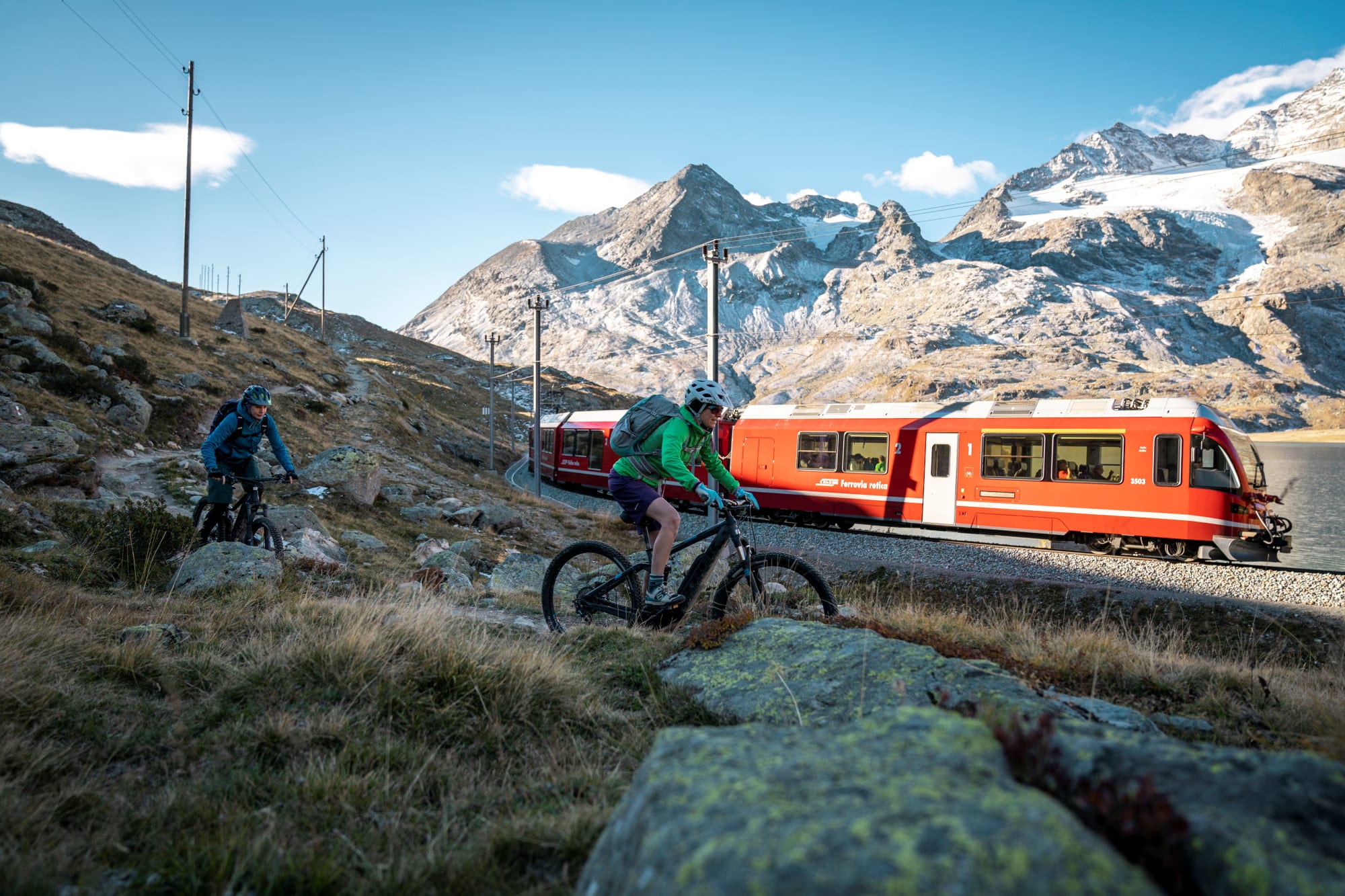 Deux cyclistes devant un train de la RhB