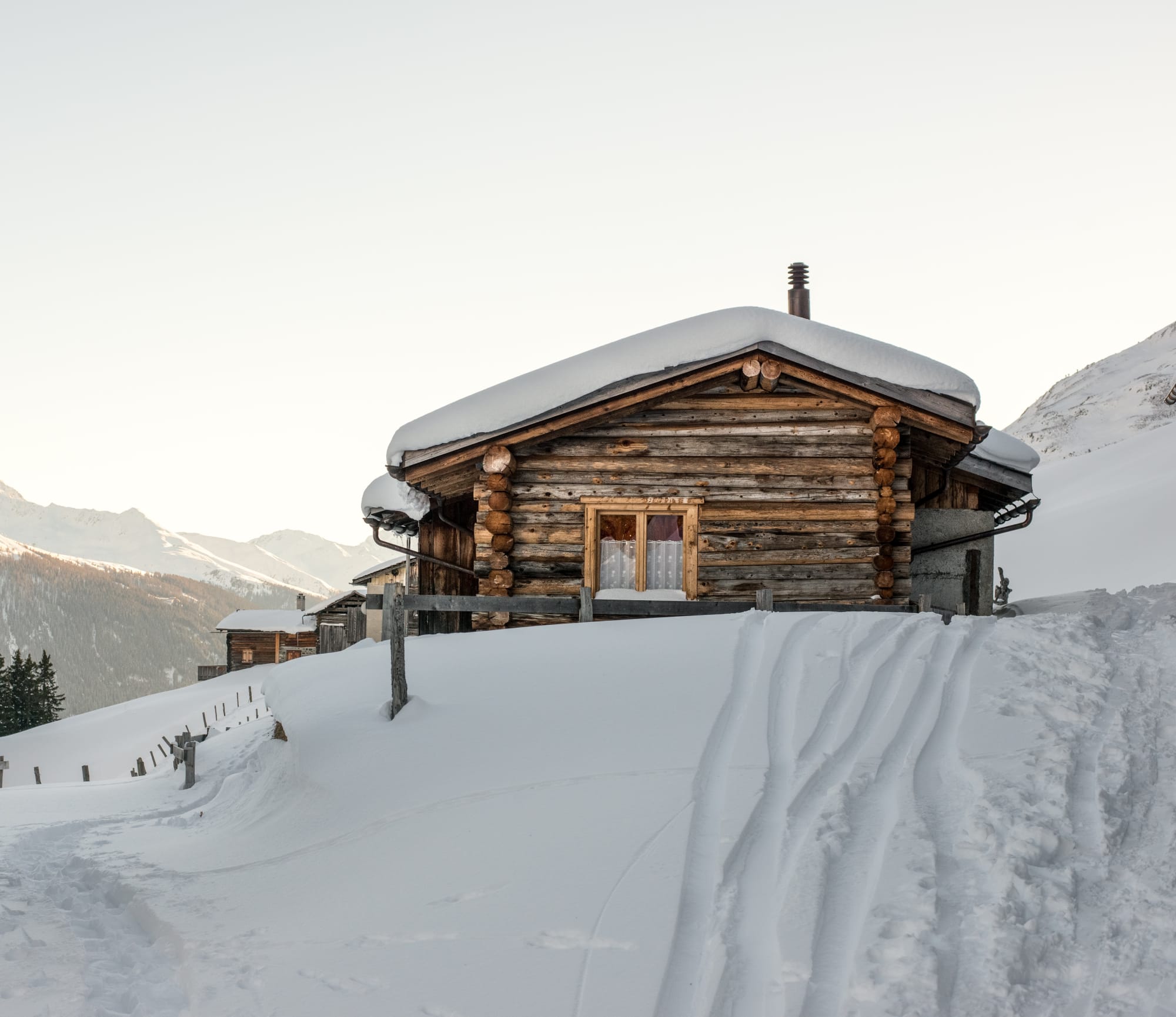 Maiensäss nella neve alta con le montagne sullo sfondo