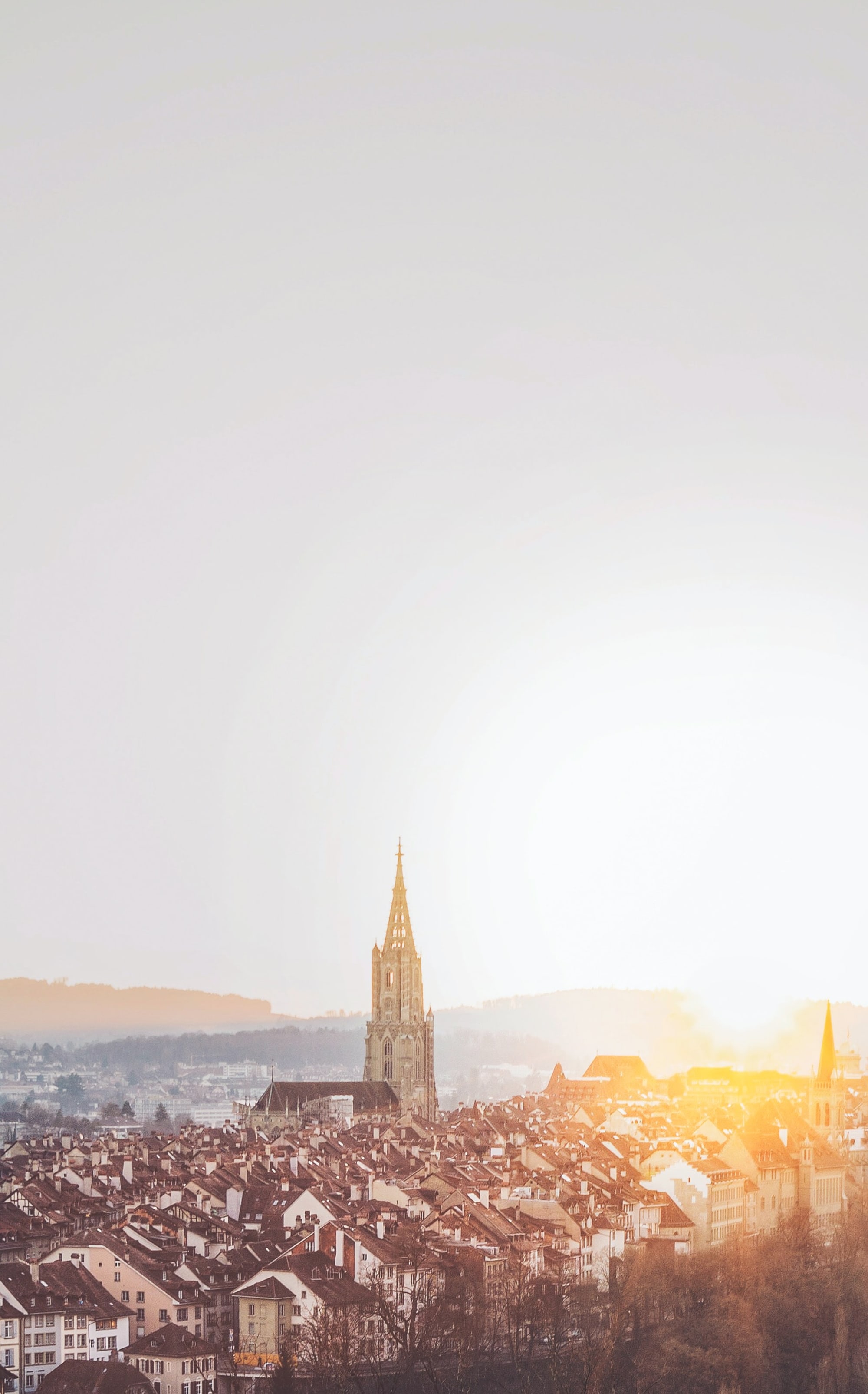Vue sur la vieille ville de Berne avec la cathédrale, coucher de soleil derrière les toits de la vieille ville.