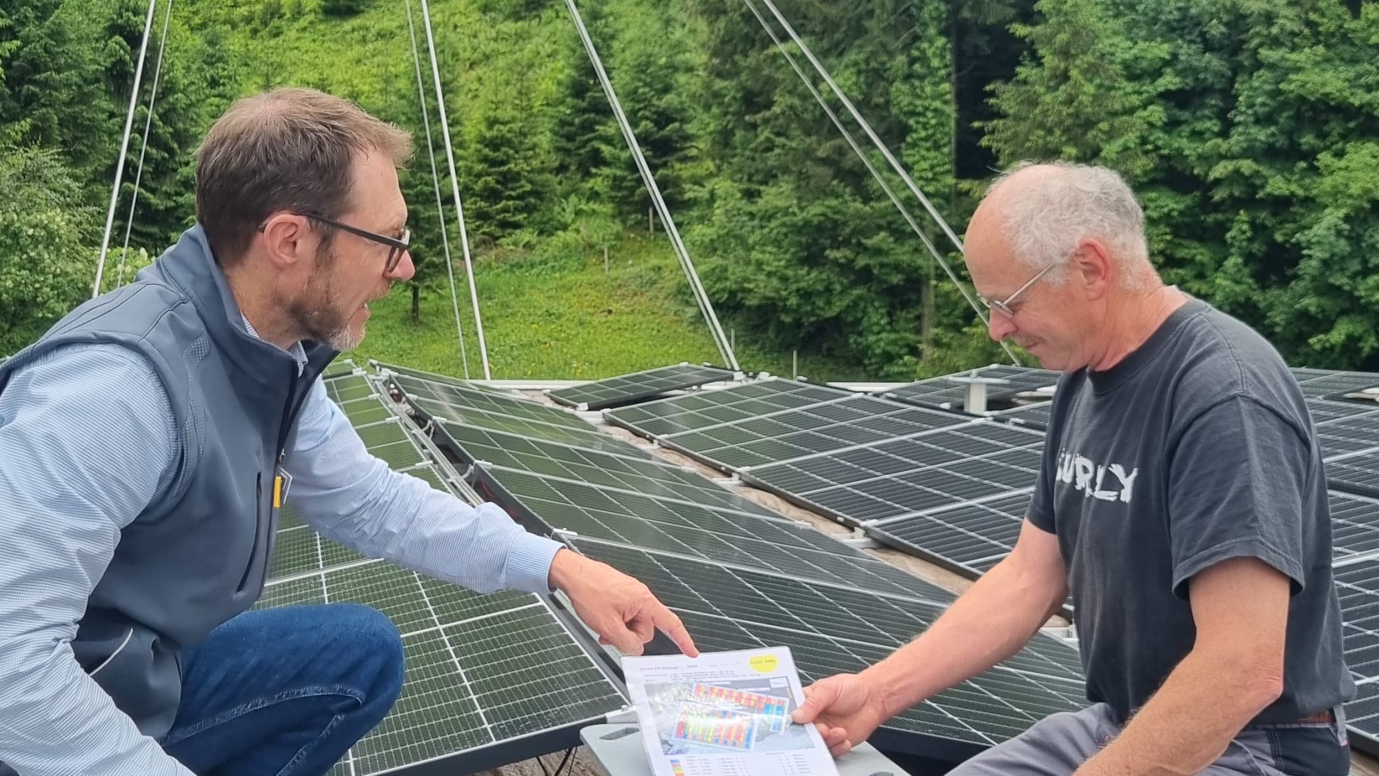 Peter Bircher und Arnold Mathis bei der neuen Photovoltaik Anlage auf dem Dach der Talstation der CabiO Luftseilbahn