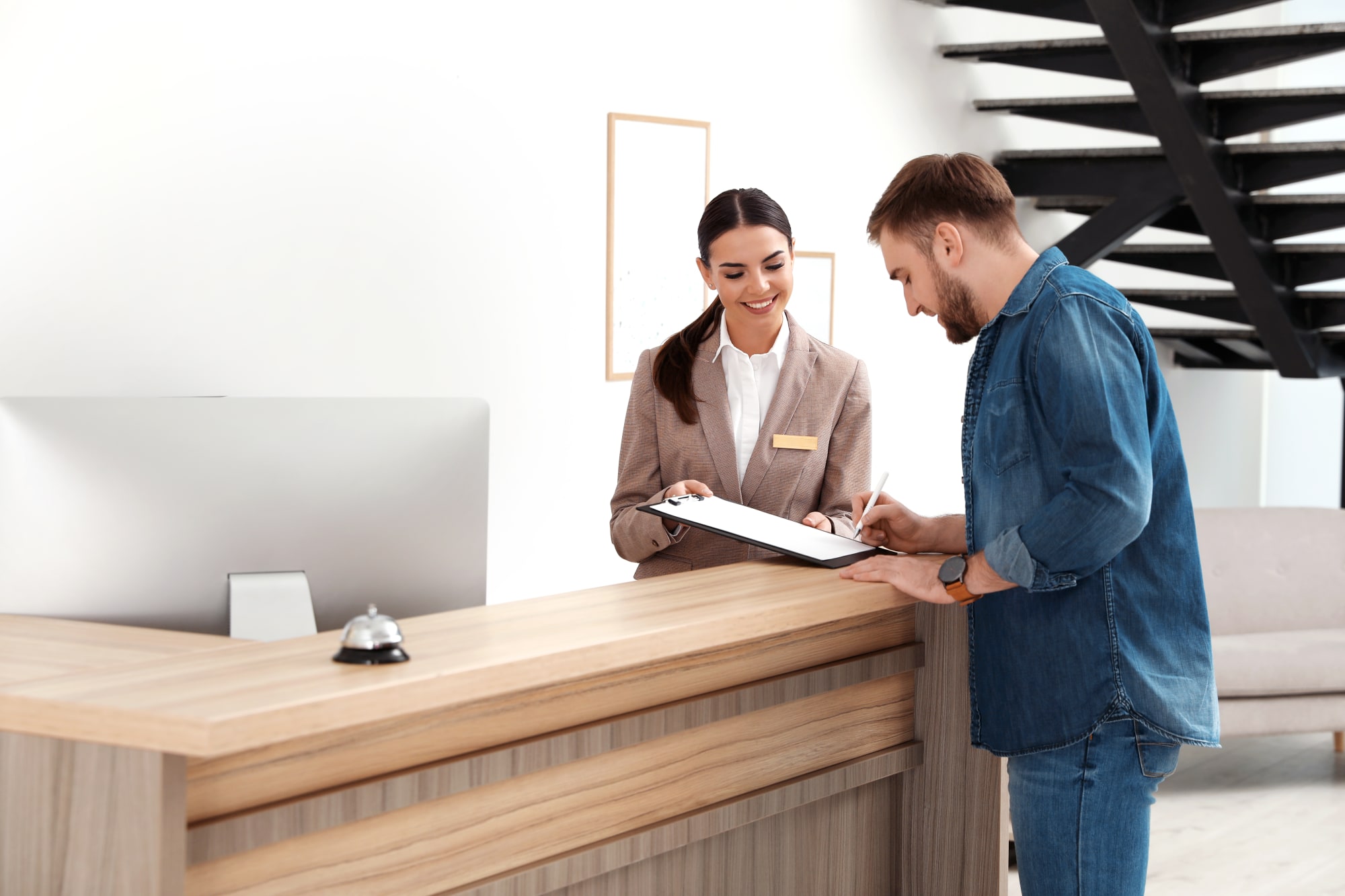 Photo d'une employée d'hôtel en conversation avec un client à la réception