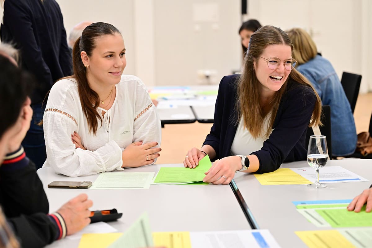 2 donne lavorano su un tavolo con dei fogli di carta