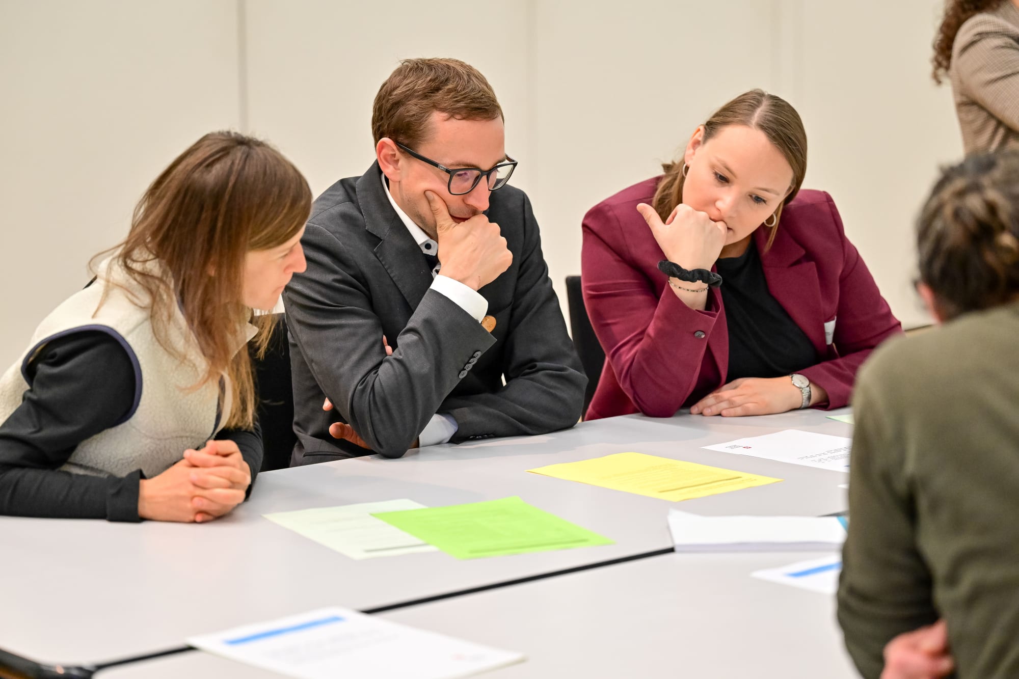 Trois personnes travaillant en groupe autour d'une table