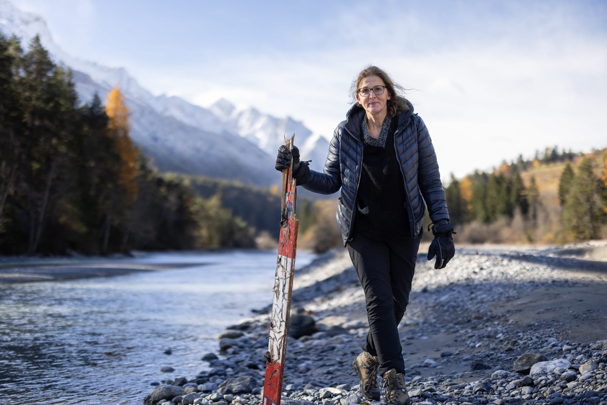 Frau mit Abfallholz am Inn Fluss