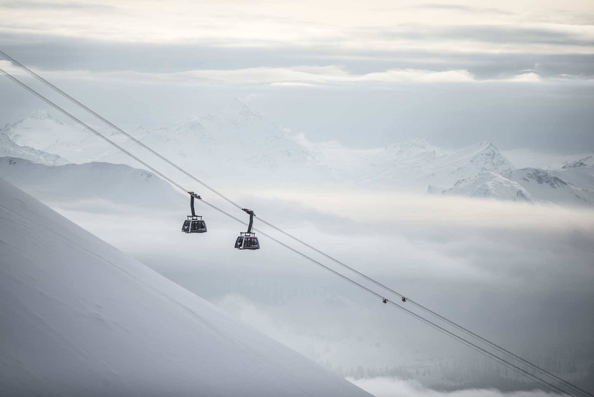 Gondelbahn vor verschneiter Bergkulisse