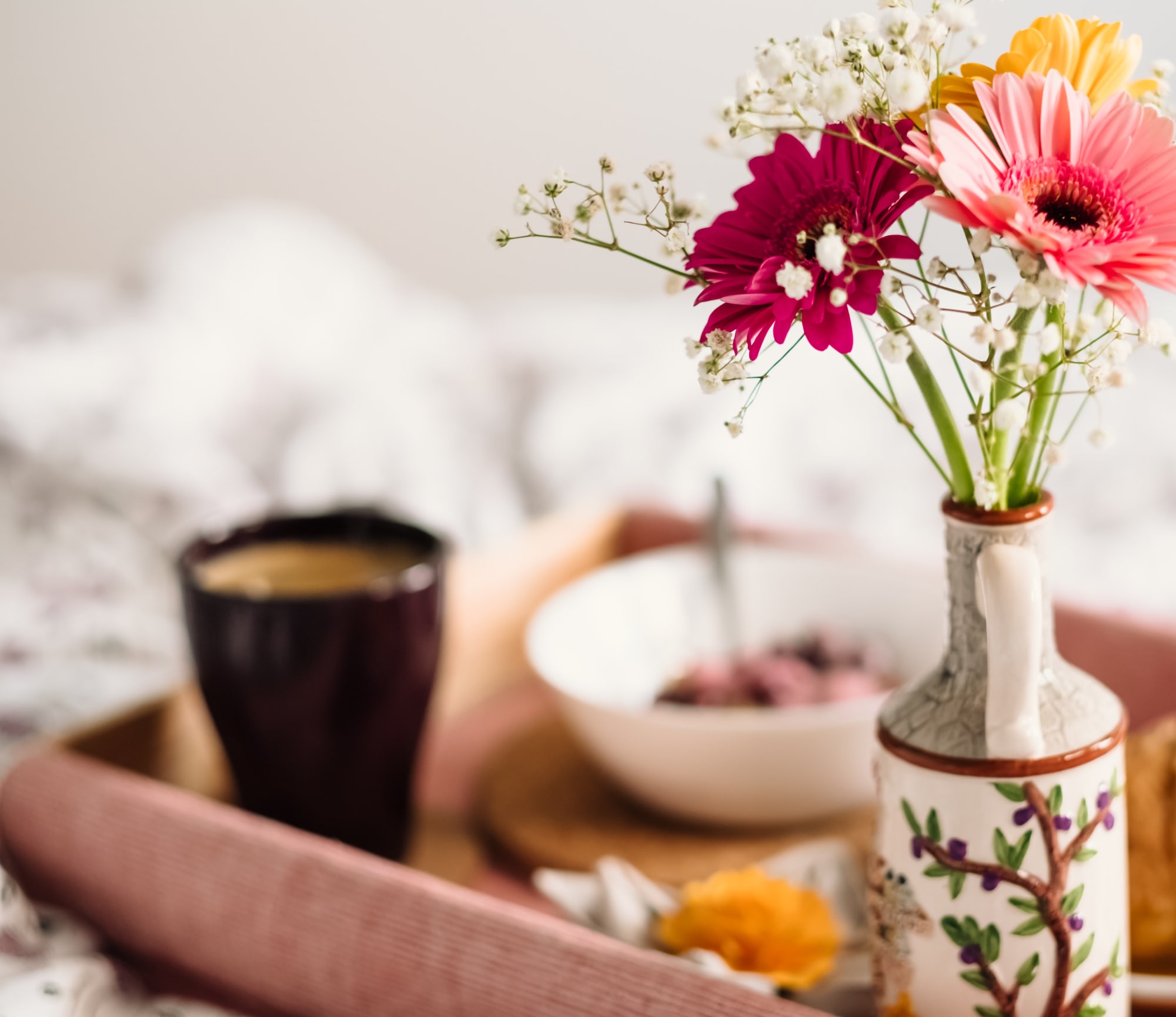 Colazione con croissant, cereali e caffè su vassoio floreale