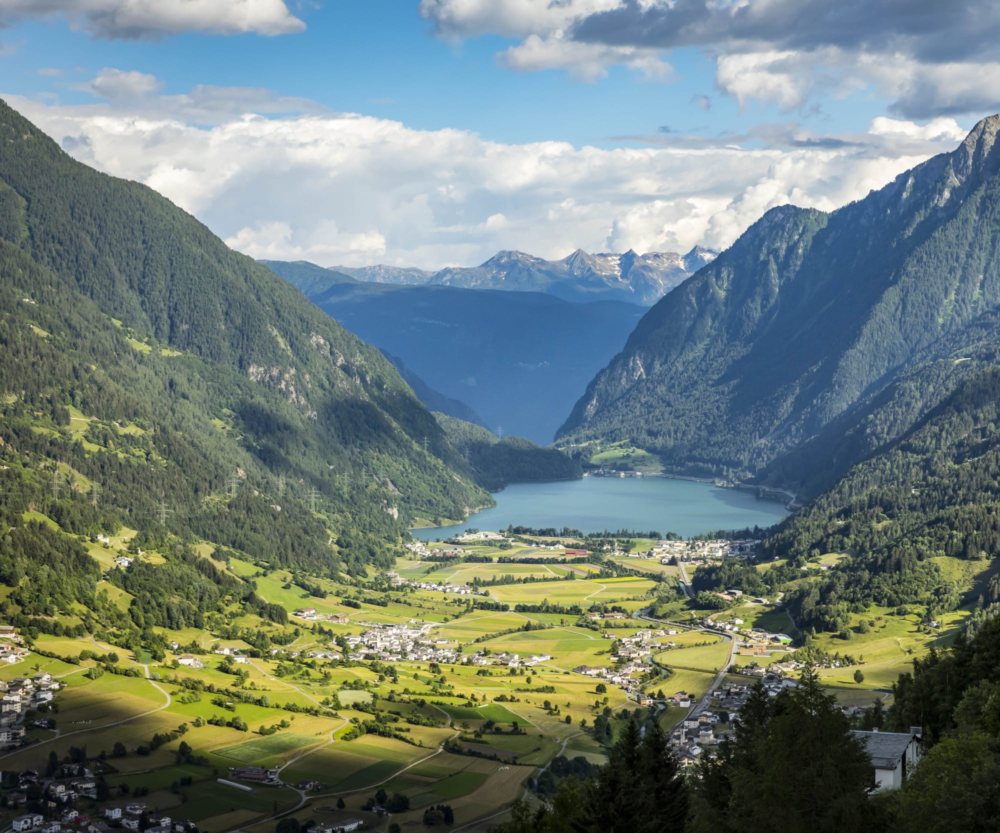 Panorama über ein Tal mit einem kleinen blauen See zwischen Bergen