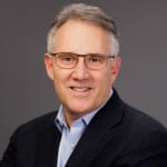 Headshot of Dan Wallace, Expert EOS Implementer, in glasses and a dark blazer
