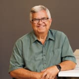 Headshot of Paul Detlefs smiling in glasses and a green checked shirt