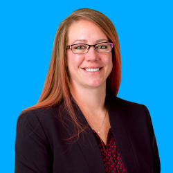 Headshot of Angela Hodges, smiling in glasses against a bright blue background