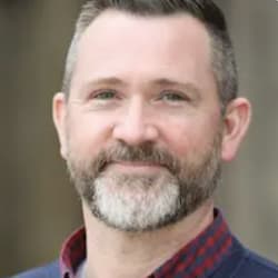 Josh Kwasny, a smiling bearded man, in the poster frame of his video testimonial