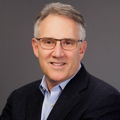 Headshot of Dan Wallace, Expert EOS Implementer, in glasses and a dark blazer