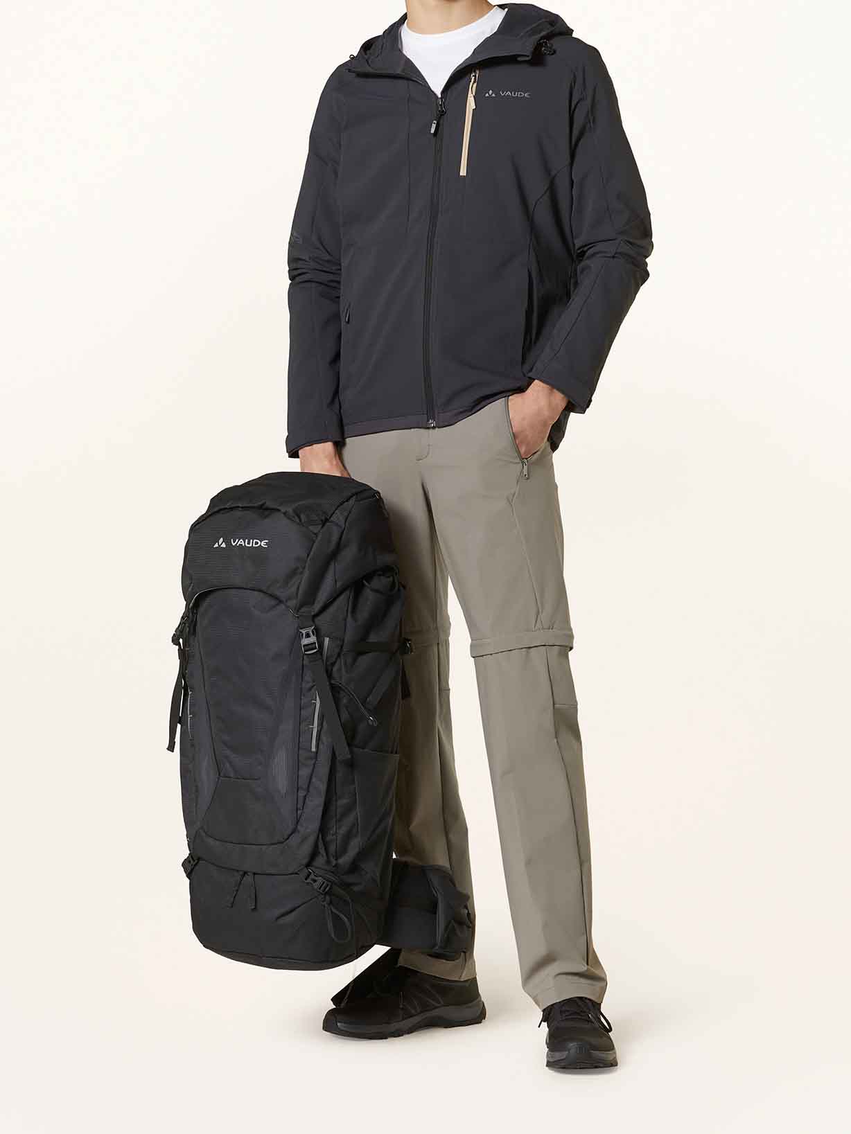 Ein Mann in Wanderkleidung posiert mit einem Trekkingrucksack für lange Wanderungen