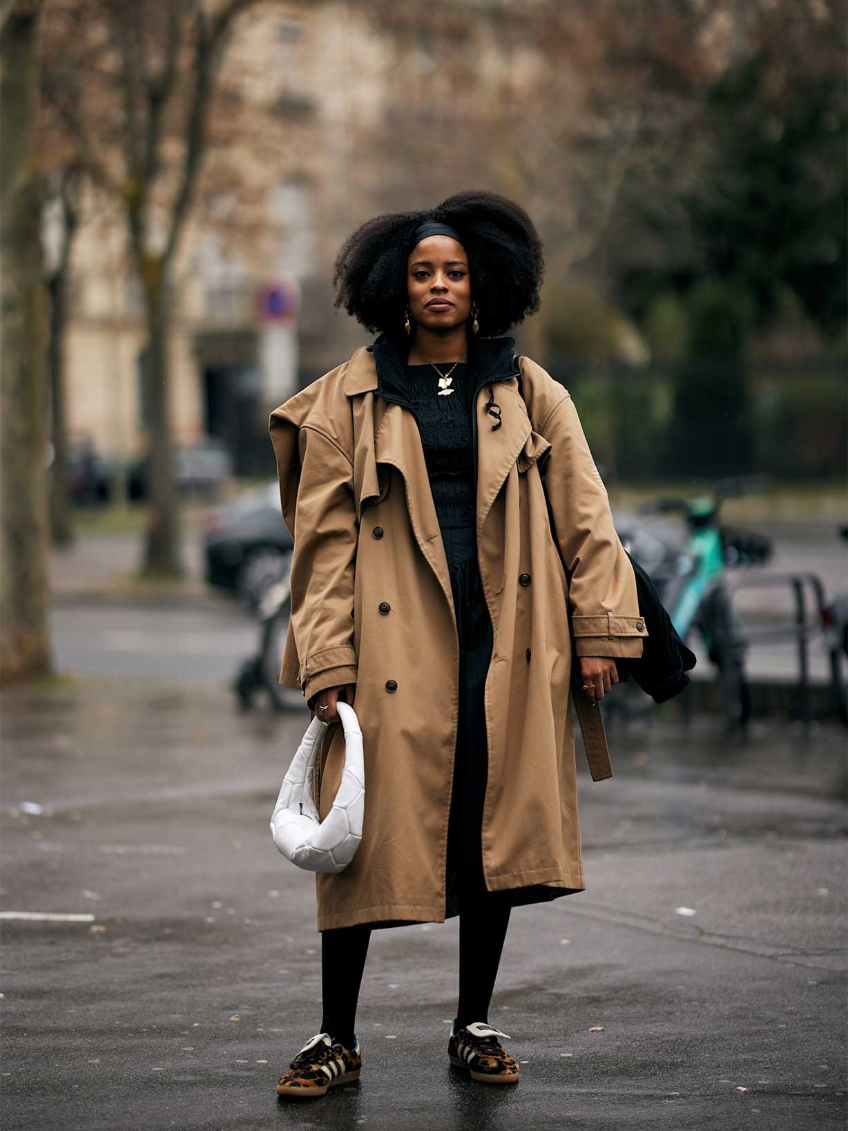 Frau trägt Animal Print Sneaker und einen langen Trenchcoat