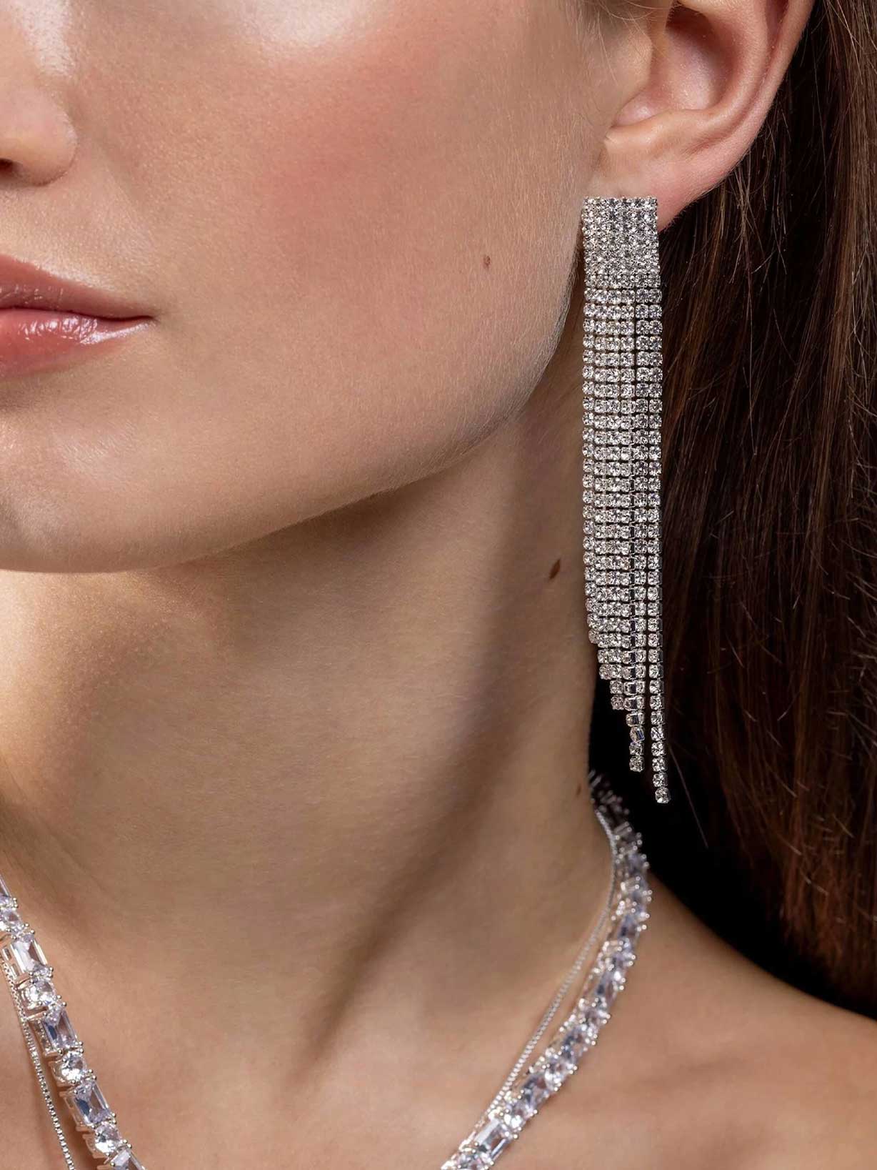 Frau trägt silberne Statement-Ohrringe