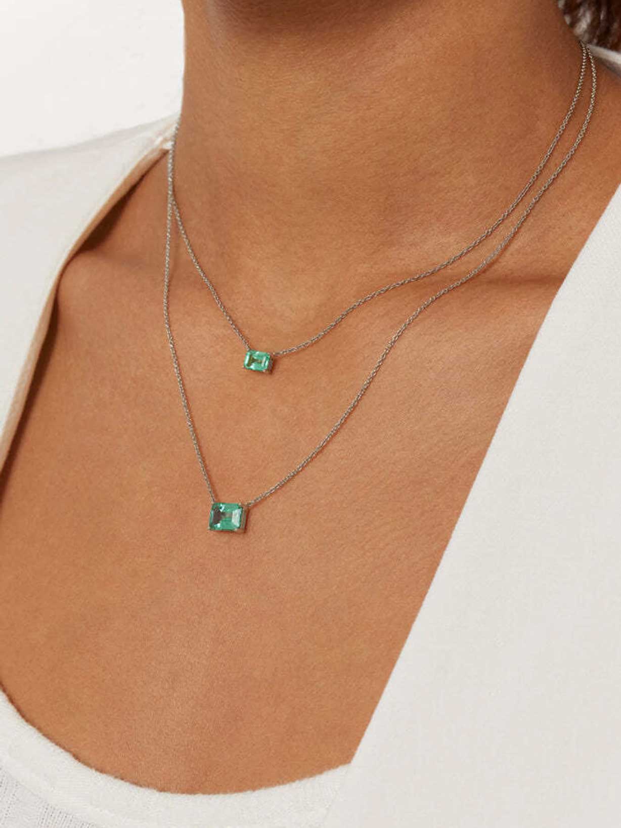 Frau trägt angesagte Halskette mit grünem Smaragd