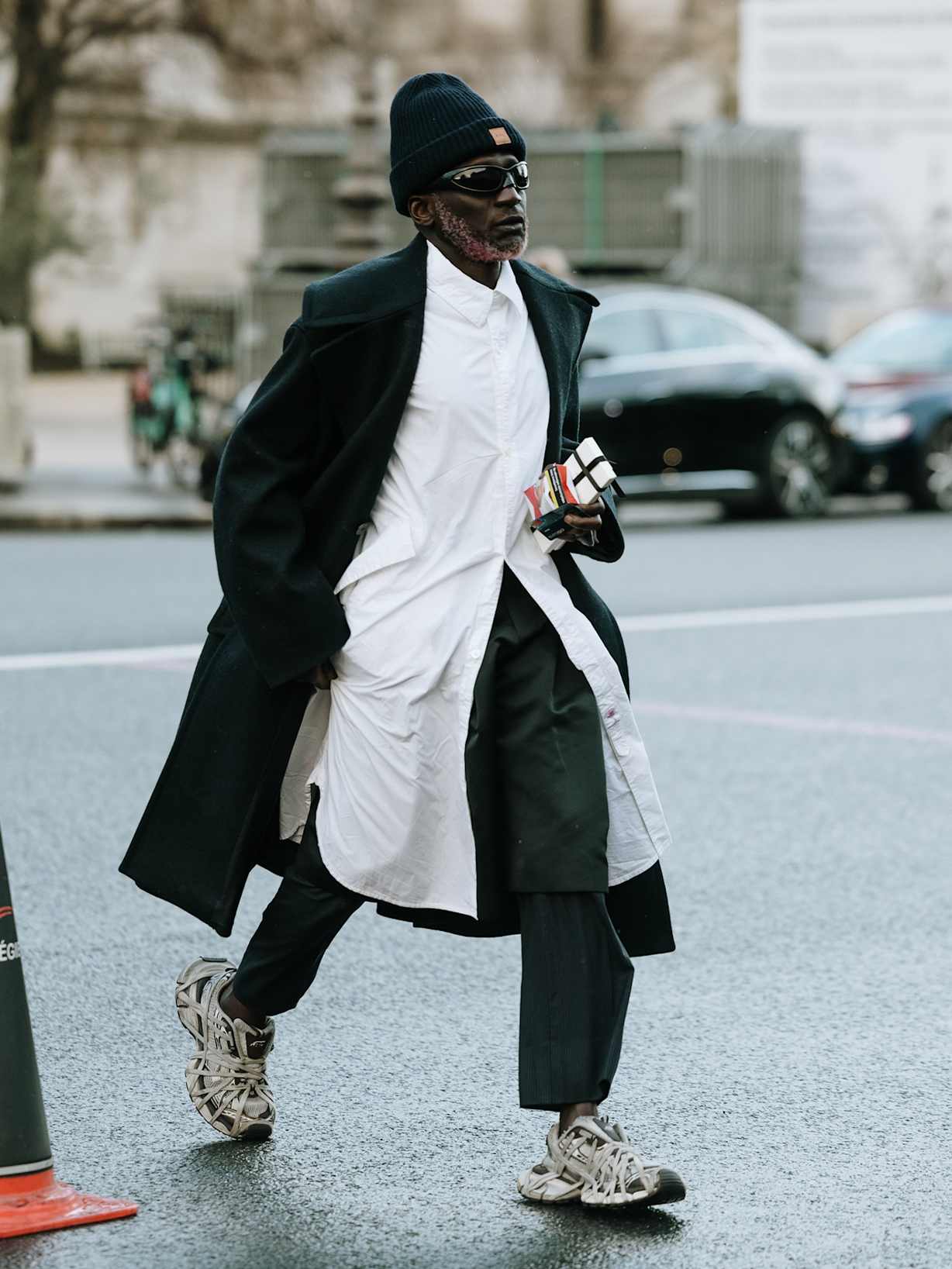 Mann stylt helle Chunky Sneaker zu Mantel, Hemd und Cargohose