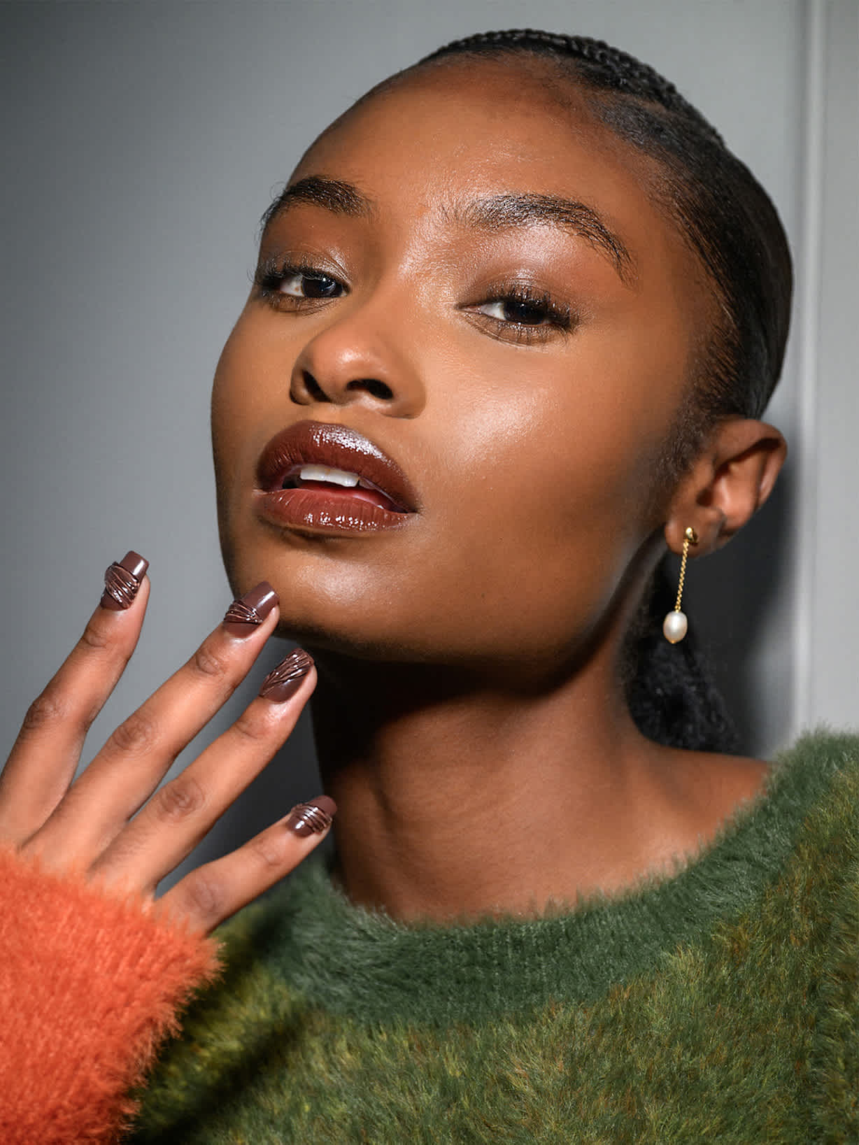 Ciemnowłosa kobieta prezentuje ciemnobrązowy lakier z aplikacjami 3D w stylu Quiet Luxury