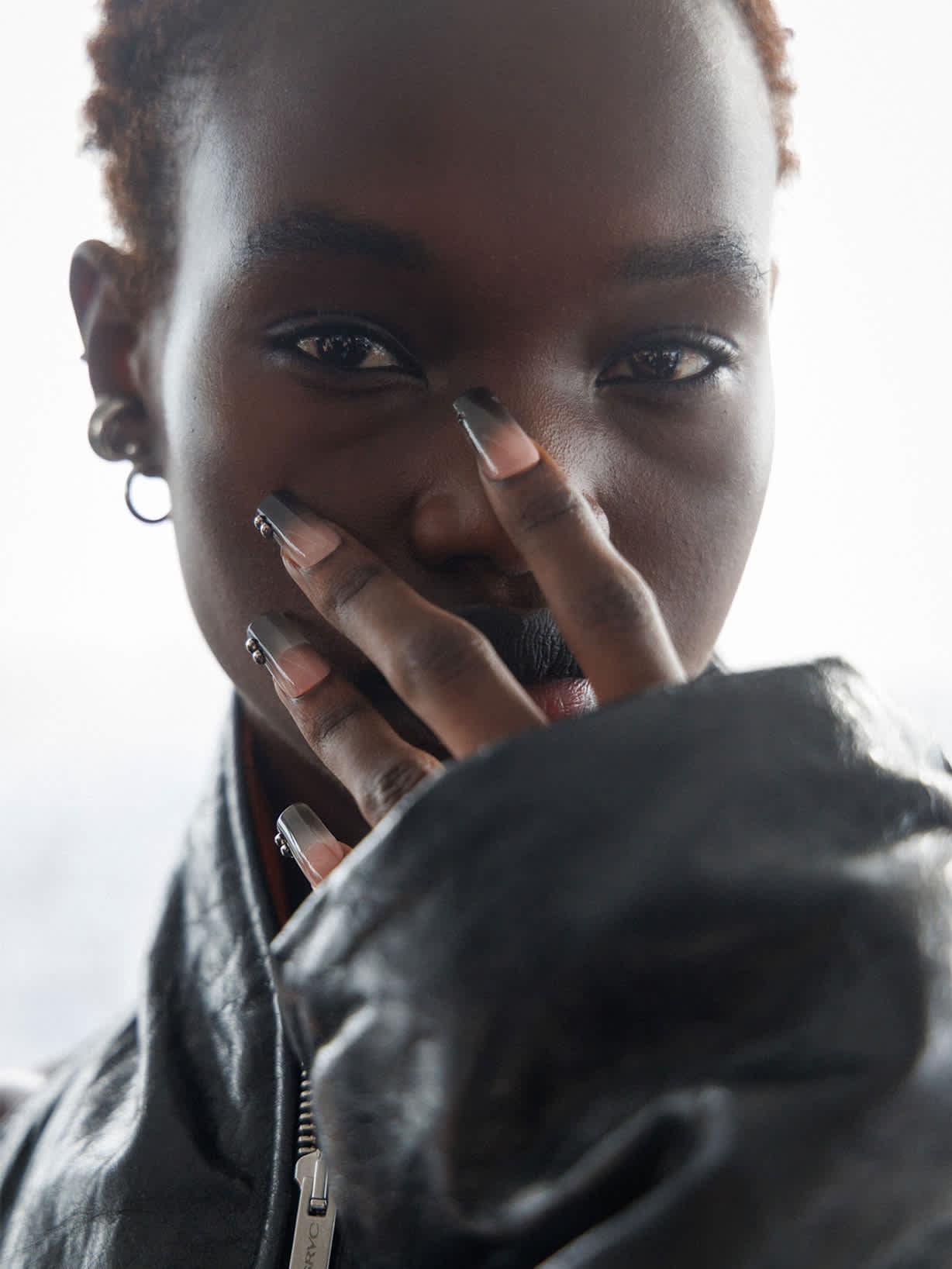 Kobieta prezentuje paznokcie w stylu ombré z przejściem kolorystycznym od czerni do nude