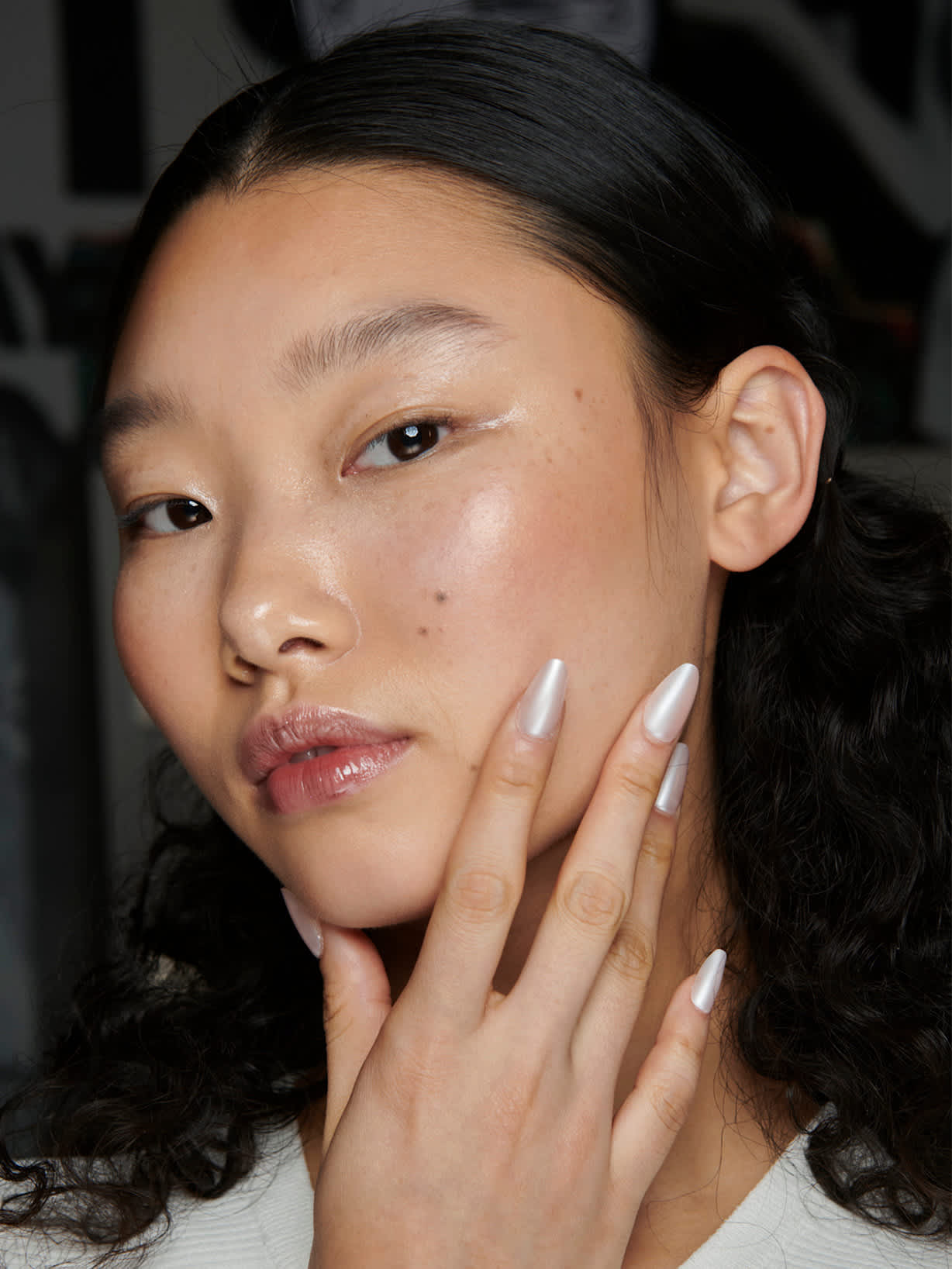 Ciemnowłosa kobieta prezentuje manicure w kolorze Cloud Dancer, trendzie kolorystycznym roku 2026