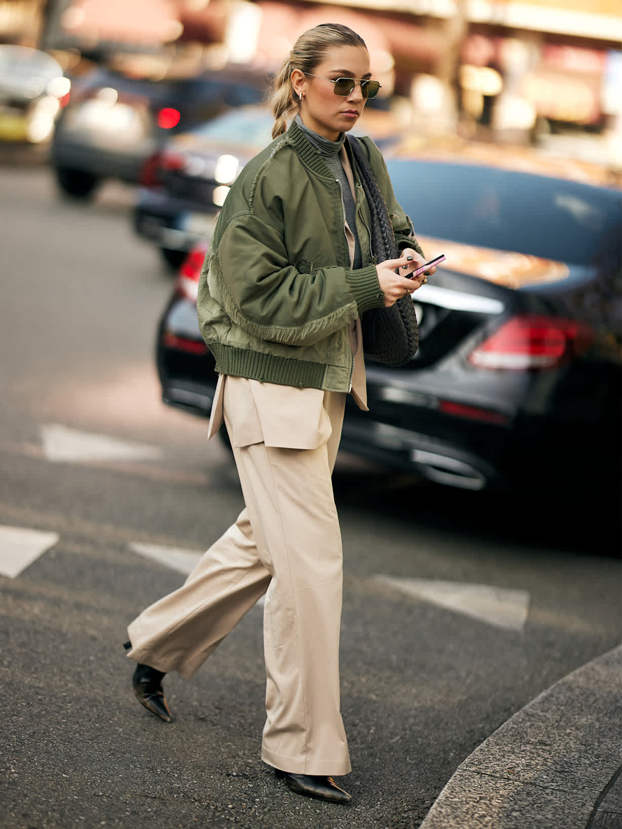 Blonde Frau stylt beige Cargohose mit olivgrünem Blouson