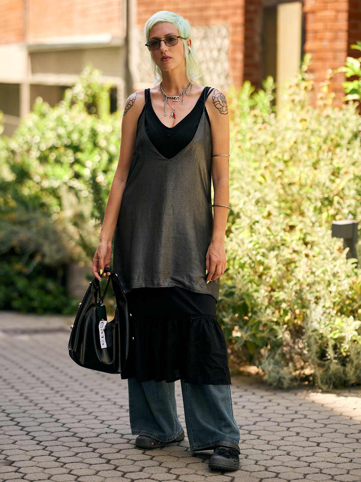 Frau mit mintgrünem Kurzhaarschnitt in lockerem Layering-Look aus Longtop, Kleid und weiter Jeans