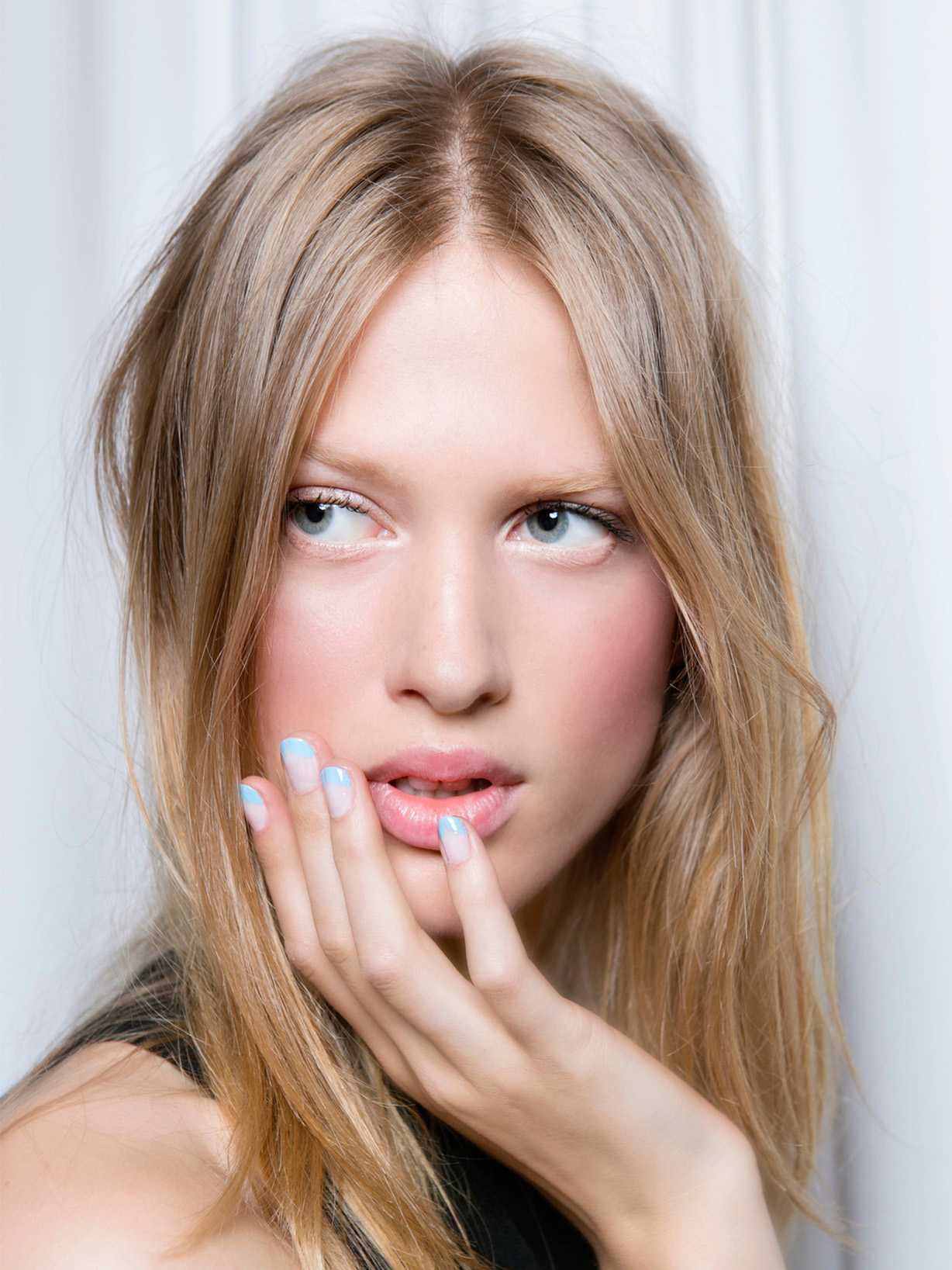 Blonde Frau trägt Turqouise French Nails