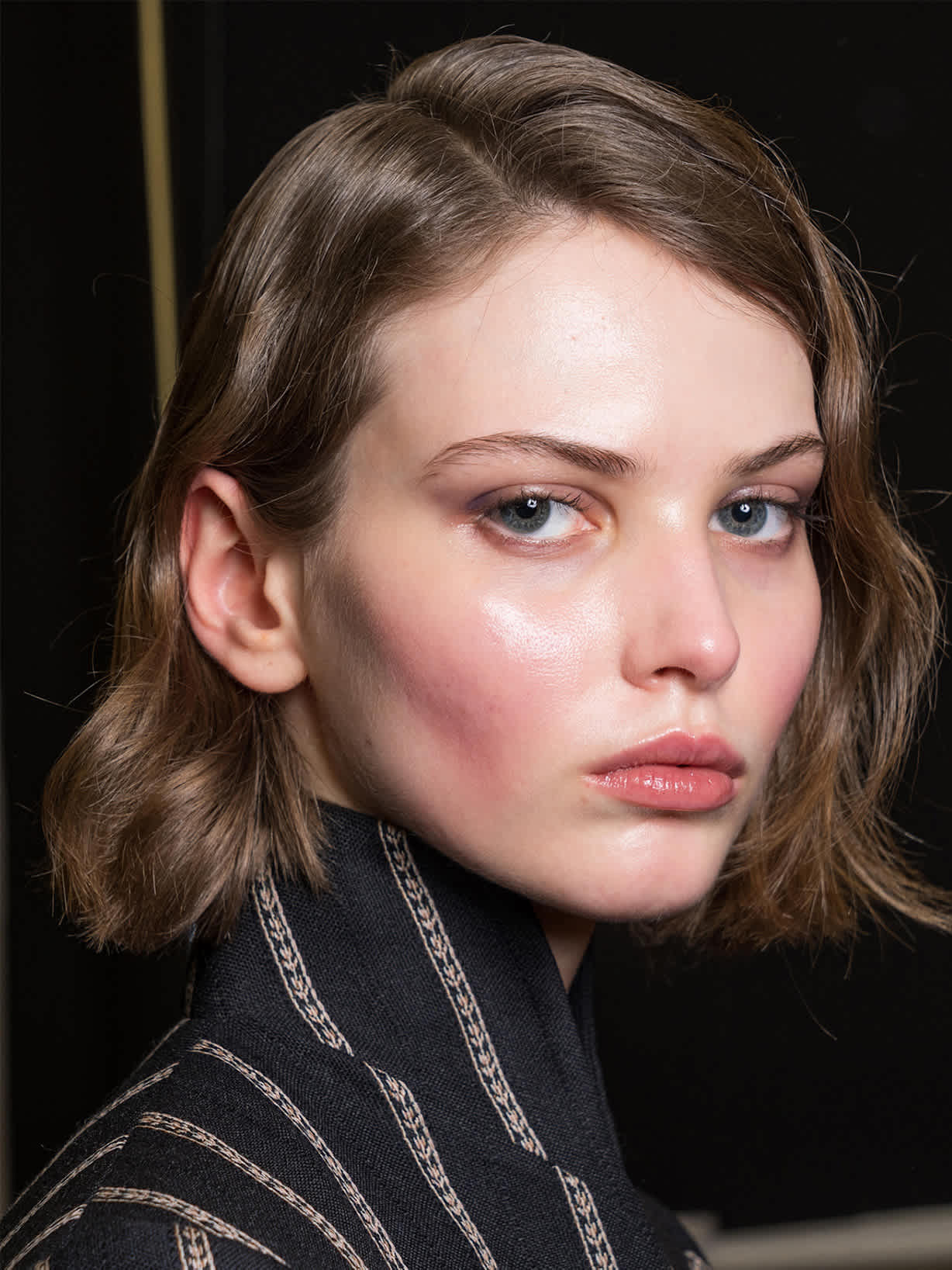 Brünette Frau trägt den Make-up-Trend Afterglow Blush