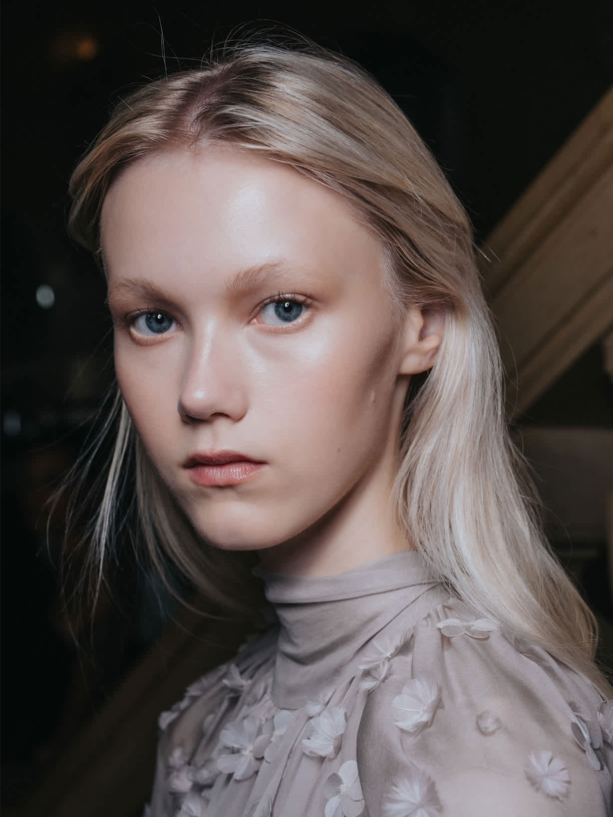 Blonde Frau trägt den Make-up-Trend Dewy Skin