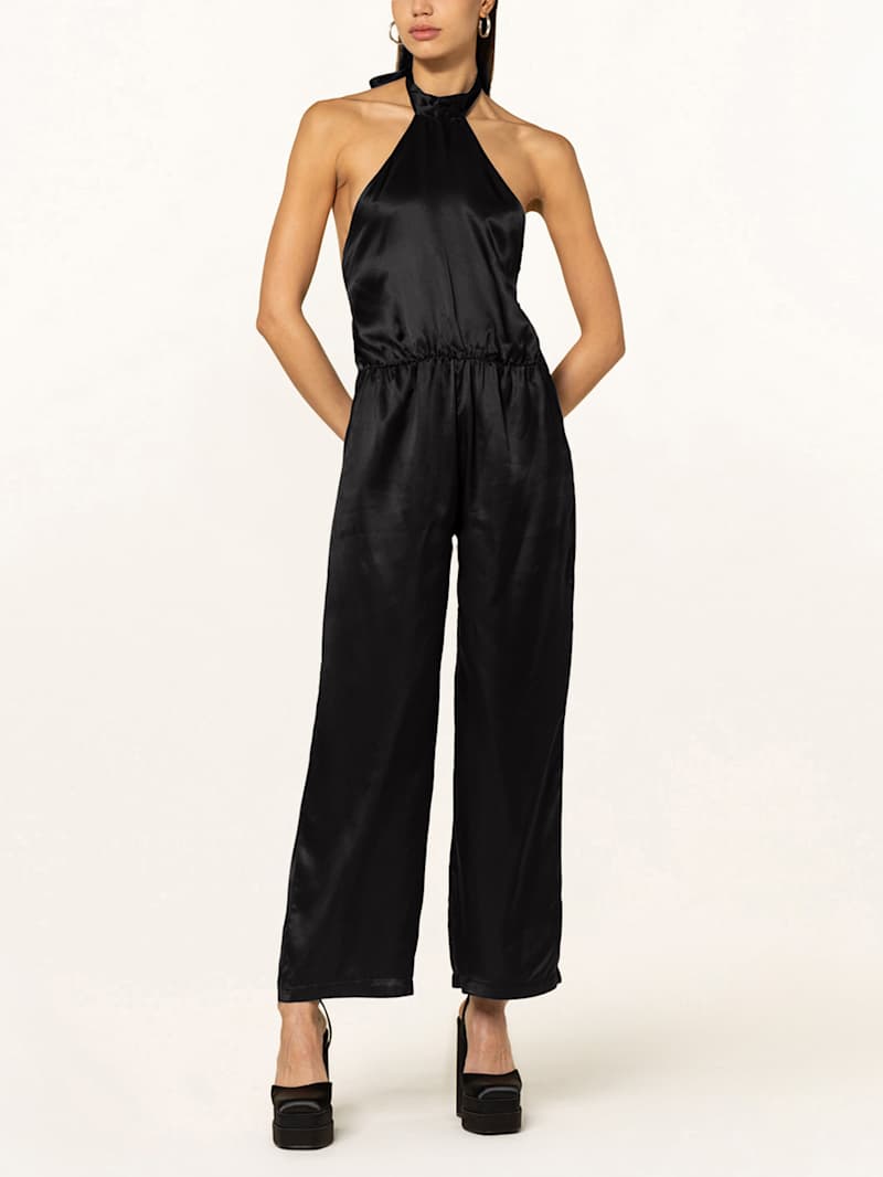 Frau trägt schwarzen Neckholder-Jumpsuit