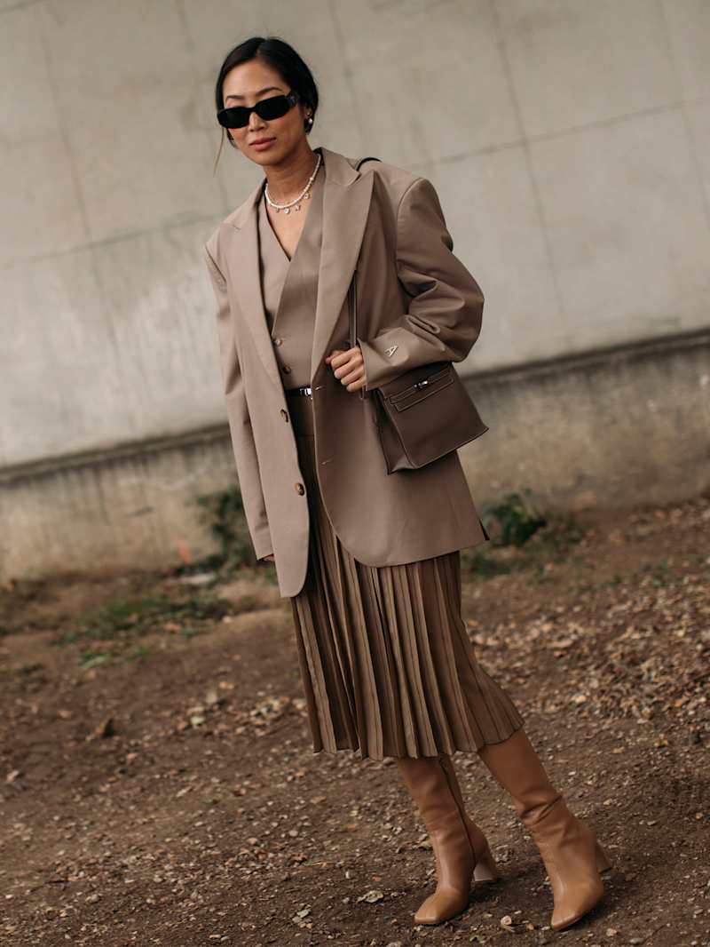 Frau trägt Business-Casual-Outfit im monochromen, beigen Look