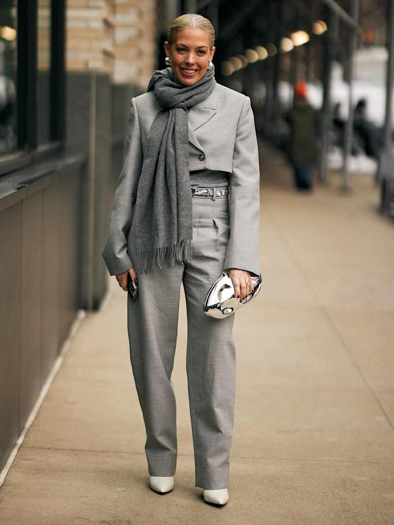 Frau trägt eine graue Stoffhose und einen grauen Kurz-Blazer